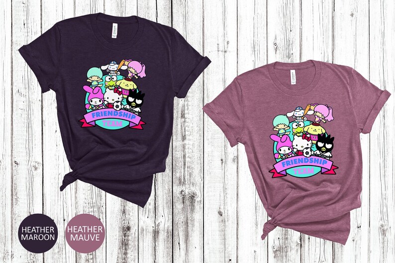 May include: Two t-shirts with a graphic print of cartoon characters. The graphic features a group of cartoon characters with the text "Friendship Team". The t-shirts are available in heather maroon and heather mauve.