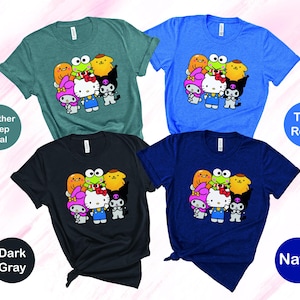 May include: Four t-shirts featuring a cartoon character graphic print. The t-shirts are in the colours heather deep teal, true royal, dark grey, and navy.
