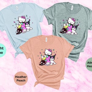 Pu&ograve; includere: Tre magliette con una stampa grafica di Hello Kitty e i suoi amici. Le magliette sono in azzurro chiaro, pesca melange e grigio melange.