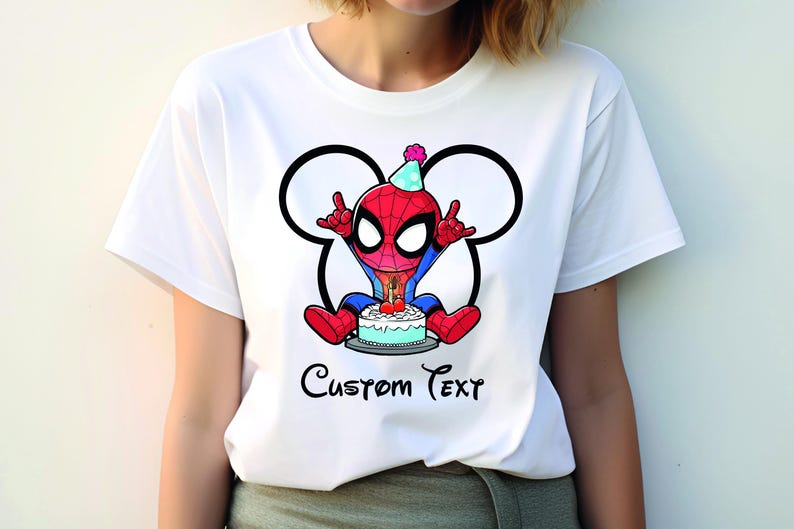 May include: White t-shirt with a cartoon Spider-Man design, wearing a party hat and holding a birthday cake. The design is framed by a Mickey Mouse-style outline, with the words "Custom Text" beneath the image.