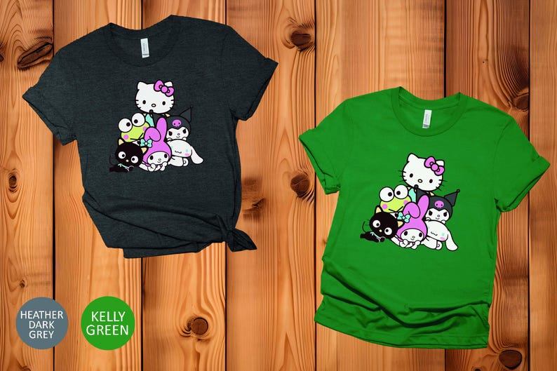 K&ouml;nnte beinhalten: Zwei T-Shirts mit einem Grafikdruck von Hello Kitty und ihren Freunden. Das linke Shirt ist dunkelgrau meliert und das rechte Shirt ist kellygr&uuml;n.
