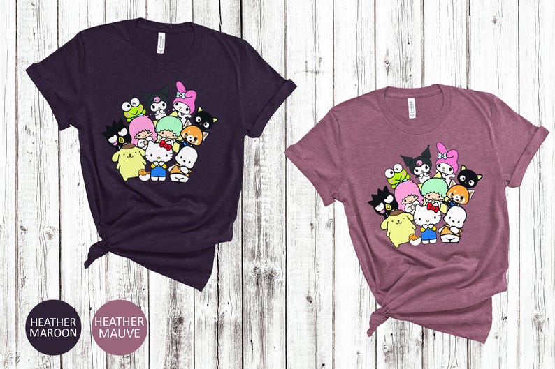 May include: Two t-shirts with a graphic print of a group of cartoon characters. The characters are all different colors and have different expressions. The t-shirts are available in heather maroon and heather mauve.