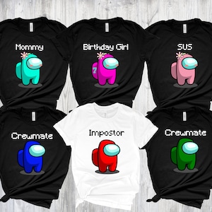 May include: Six black t-shirts with different Among Us character designs. The designs include "Mommy", "Birthday Girl", "SUS", "Crewmate", "Crewmate", and "Imposter".
