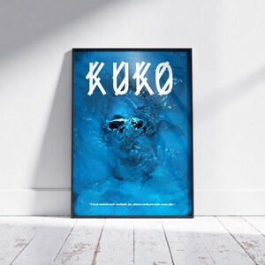Könnte beinhalten: Ein rechteckiges gerahmtes Wandbild mit einem tiefblauen Wasserhintergrund und einem untergetauchten Gesicht. Das Wort KOKO ist in großen weißen stilisierten Buchstaben oben gedruckt, und der Text Und wenn ich schlaf, ja, dann träum ich von dir steht unten.