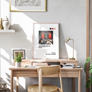 K&ouml;nnte beinhalten: Ein Holzschreibtisch mit einer Lampe, einer Topfpflanze und einem gerahmten Poster mit dem Text "Leb es oder lass es" und dem Datum "28. M&auml;rz 2020".