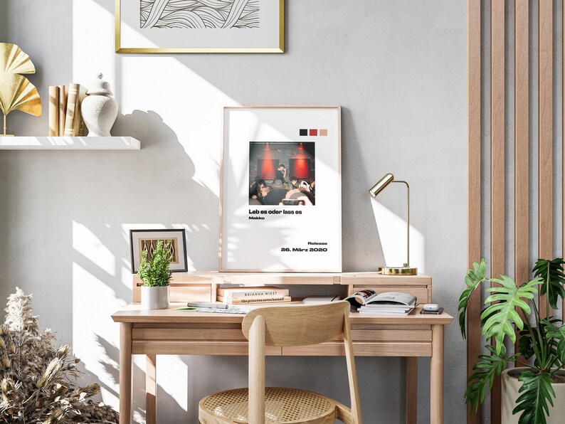 K&ouml;nnte beinhalten: Ein Holzschreibtisch mit einer Lampe, einer Topfpflanze und einem gerahmten Poster mit dem Text "Leb es oder lass es" und dem Datum "28. M&auml;rz 2020".