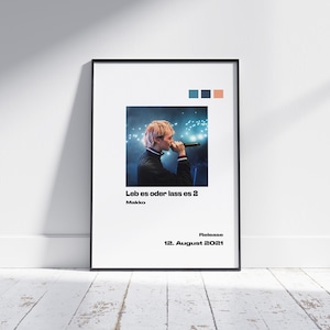 May include: A black and white poster featuring a photograph of a person singing into a microphone. The text on the poster reads "Leb es oder lass es 2" and "Makko". The poster also includes the text "Release 12. August 2021".