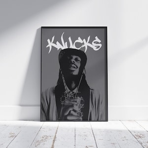 May include: Black and white poster featuring a portrait of a person wearing a hat and a chain necklace. The text "KNUCKS" is written in white graffiti-style lettering at the top of the poster.