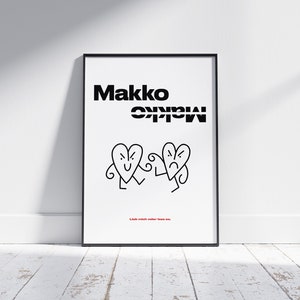 May include: Black framed art print with the word "Makko" in bold black letters above two cartoon heart characters. One heart is smiling, the other is frowning. The text "Lieb mich oder lass es" is at the bottom.