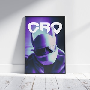 May include: A framed poster featuring a person wearing a white helmet with a visor and ear-like protrusions. The poster has a purple and blue gradient background with the word "CRO" in white block letters.