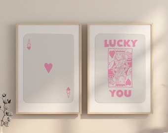 May include: Two framed prints of playing cards with pink hearts and the text "LUCKY YOU" on one print.