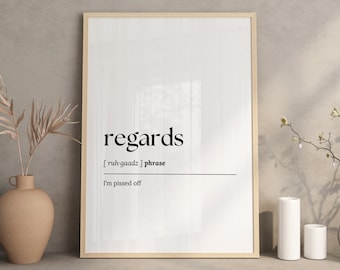 May include: A framed print with the word "regards" in a bold, black font. Below, the phonetic pronunciation and the phrase "I'm pissed off" are displayed. The print is in a light wooden frame, with a neutral background.