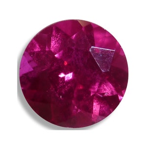 May include: A deep red ruby gemstone with a round cut and a faceted surface.