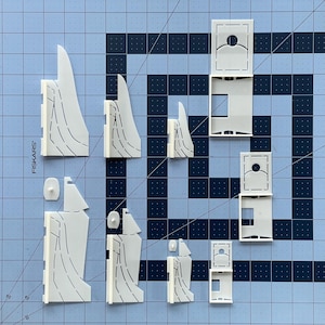 K&ouml;nnte beinhalten: Ein Satz wei&szlig;er Papierbastelteile zum Bau eines Modells. Die Teile sind ausgeschnitten und bereit zum Zusammenbauen. Die Teile sind mit dem Wort "FISKARS" beschriftet.