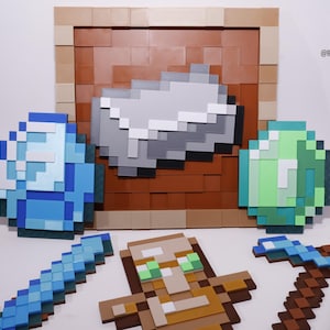 Pode incluir: Uma coleção de itens pixelados com tema Minecraft. Inclui um diamante azul, uma esmeralda verde, uma barra cinza, uma espada, uma picareta, um personagem e um bloco emoldurado. Os itens são em vários tons de azul, verde, cinza, marrom e bege.