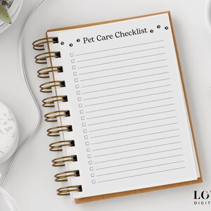 Puede incluir: Una libreta blanca de espiral con una cubierta marr&oacute;n y el texto "Pet Care Checklist" impreso en la portada. La libreta tiene una encuadernaci&oacute;n en espiral dorada y est&aacute; sobre una superficie blanca.