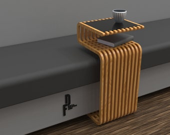 Puede incluir: Una mesa auxiliar de madera con una tapa de vidrio negro. La mesa tiene un diseño único con listones curvos y está unida a un banco gris.