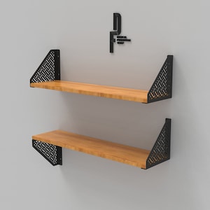 Könnte beinhalten: Zwei Holzregale mit schwarzen Metallkonsolen. Die Konsolen haben ein geometrisches Muster.