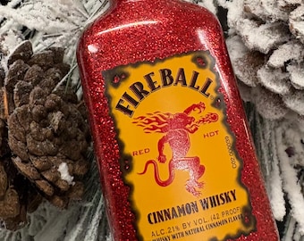 Adorno navideño hecho con botella de whisky con canela reciclada.