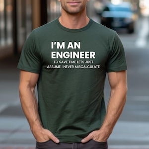 May include: Dark green t-shirt with the text "I'M AN ENGINEER" in white block letters. Below the text is the phrase "TO SAVE TIME LETS JUST ASSUME I NEVER MISCALCULATE". The shirt has a crew neck and short sleeves.