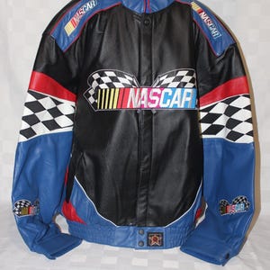 May include: A black leather jacket with blue, red, and white accents. The jacket features a checkered pattern on the sleeves and a large "NASCAR" logo on the front.