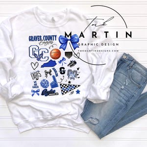 May include: White sweatshirt with a blue and white graphic design featuring the text "Graves County Eagles" and various sports-themed icons. The design includes a basketball, a heart, a star, a cheerleading pom-pom, and a football helmet.