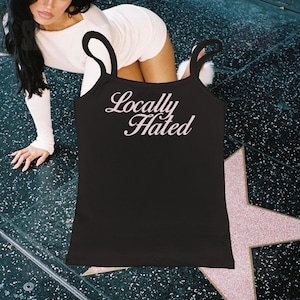 May include: Black tank top with the text "Locally Hated" in pink lettering.