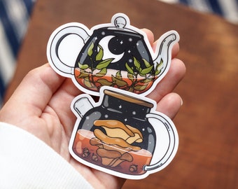 May include: Two teapots with a starry night sky design. One teapot is filled with green leaves and the other is filled with mushrooms.