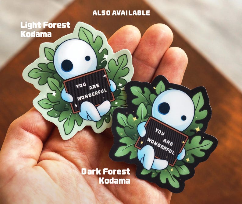 May include: Two sticker designs featuring a white Kodama character holding a sign that says "You are wonderful". The left sticker is a light green forest scene and the right sticker is a dark green forest scene. The text "Also Available" is at the top of the image.
