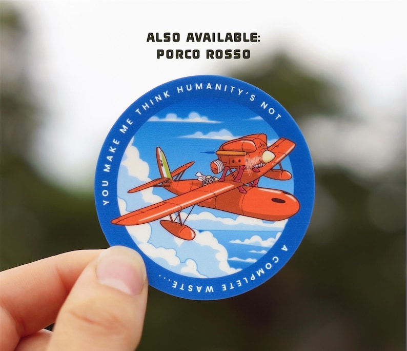 May include: A blue and white circular sticker with a red and white seaplane flying in a blue sky with white clouds. The text on the sticker reads "You make me think humanity's not a complete waste..." and "Also available: Porco Rosso".