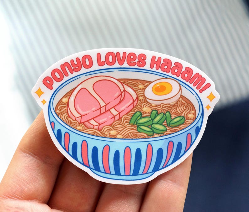 Pu&ograve; includere: Un adesivo raffigurante una ciotola di ramen con noodles, una fetta di maiale, un uovo sodo e verdure verdi. Il testo "Ponyo Loves haaaam!" &egrave; scritto in rosso intorno alla ciotola.