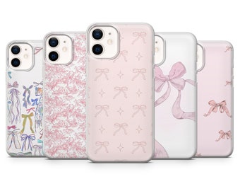 Pode incluir: Cinco capas de telefone diferentes com designs de laços rosa e branco. As capas são transparentes e permitem que o telefone seja visto através do design.