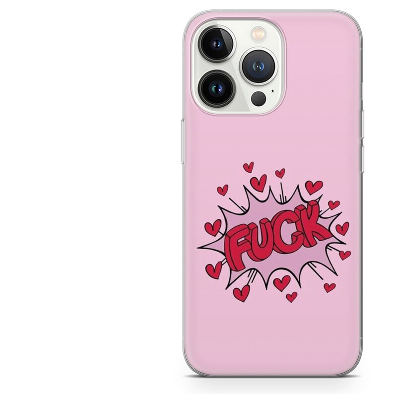 Pode incluir: Uma capa de telefone rosa com um design gr&aacute;fico. O design apresenta a palavra "FUCK" em letras 3D vermelhas dentro de uma explos&atilde;o branca com cora&ccedil;&otilde;es vermelhos.