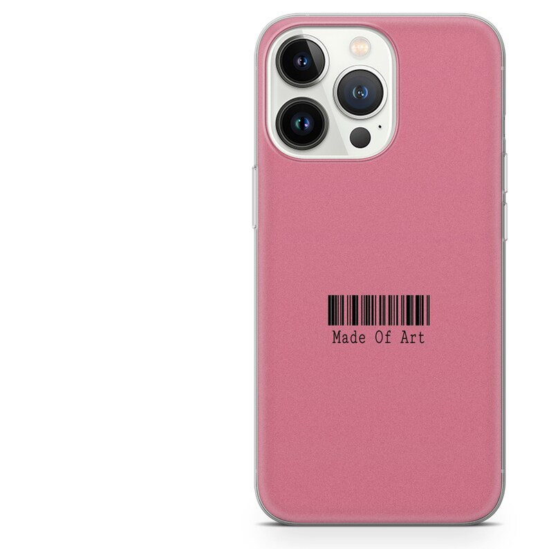 Pode incluir: Uma capa de telefone rosa com borda transparente. A capa tem um gr&aacute;fico de c&oacute;digo de barras e as palavras "Made Of Art" impressas em preto. A capa &eacute; projetada para um smartphone.