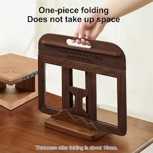May include: A wooden book stand with a quote engraved on the front: "The Mountains Are Calling And I Must Go". The stand is folded and has a handle on the top. The stand is 18 mm thick when folded.