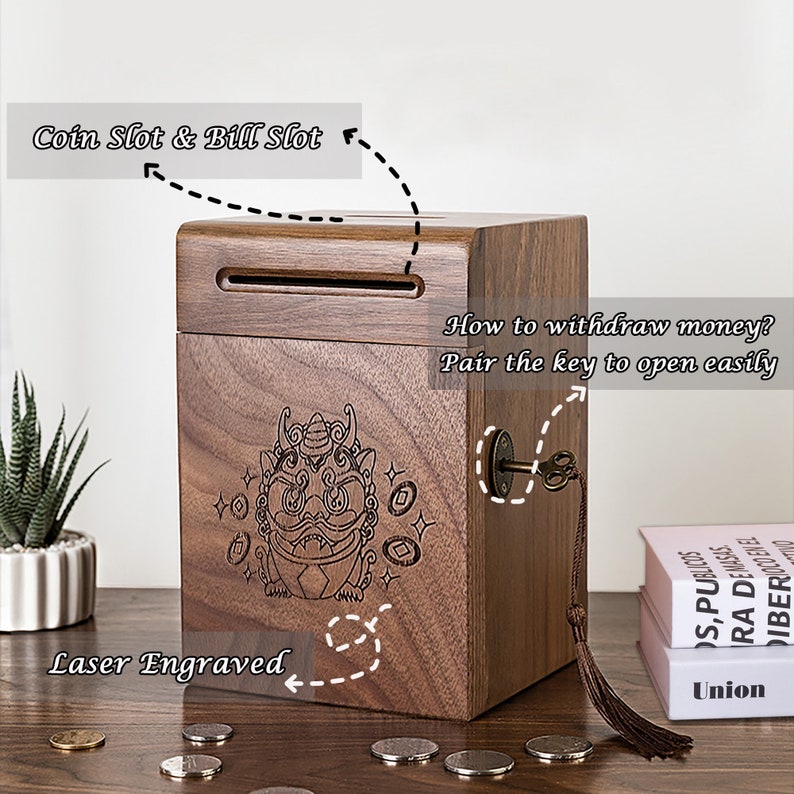 Peut inclure: Une bo&icirc;te &agrave; monnaie en bois avec un trou de serrure et une fente pour les pi&egrave;ces et les billets. La bo&icirc;te est d&eacute;cor&eacute;e d'un motif grav&eacute; au laser repr&eacute;sentant une cr&eacute;ature mythique et des pi&egrave;ces de monnaie. Le texte "Comment retirer de l'argent ? Jumelez la cl&eacute; pour ouvrir facilement" est &eacute;crit sur la bo&icirc;te.
