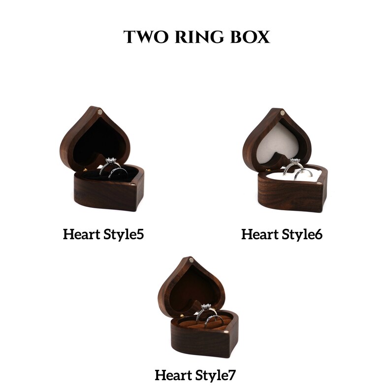 May include: Three wooden heart-shaped ring boxes with lids open. The boxes are dark brown and have a velvet interior. The boxes are labeled "Heart Style 5", "Heart Style 6", and "Heart Style 7".