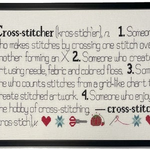 May include: A framed cross-stitch design with the definition of a cross-stitcher. The definition reads: "Cross-stitcher (kros-sticher), n. 1. Someone who makes stitches by crossing one stitch over another forming an X. 2. Someone who creates art using needle, fabric and colored floss. 3. Someone who counts stitches from a grid-like chart to create stitched artwork. 4. Someone who enjoys the hobby of cross-stitching - cross-stitch (kros-stich)*"