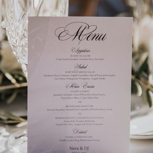 Może przedstawiać: Biała karta menu z czarnym tekstem, na której wymienione są przystawki, sałatka, danie główne i deser na przyjęcie weselne. Menu zawiera takie dania jak grillowane małże, sałatka z młodych zielonych liści, grillowany łosoś, duszona wołowina i waniliowy biszkopt. Na dole karty widnieje napis "Neva & DJ 21 lipca 2022".