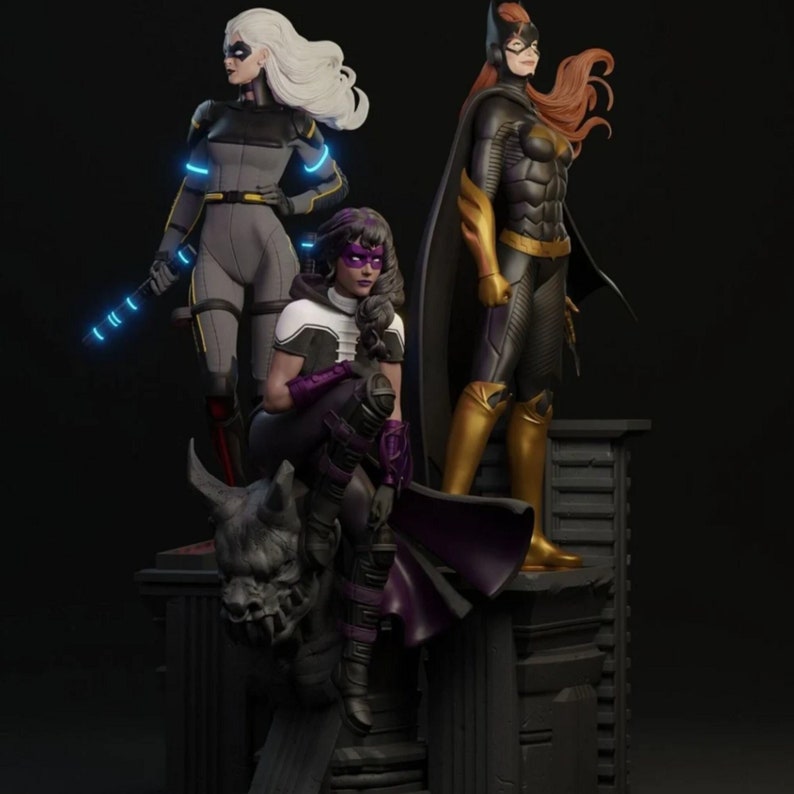May include: A detailed sculpture featuring three female superhero figures. The figures are in dynamic poses, with one holding a glowing blue baton. The color palette includes gray, black, purple, and gold, with a dark background.