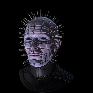 May include: A close-up of a horror movie character's head with a metal grid and nails protruding from the head. The character has a pale face with dark eyes and a serious expression.