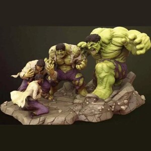 May include: A green Hulk figurine with ripped clothing, standing on a rocky base. Two smaller Hulk figurines are fighting in the foreground. The larger Hulk is in a fighting pose with his fists clenched.