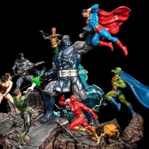 Puede incluir: Figura detallada con múltiples superhéroes de DC Comics en acción. Superman, con capa roja, lucha en el aire contra una gran figura oscura. Otros héroes incluyen a Batman, Wonder Woman, Green Lantern y Flash. La base es un terreno rocoso.