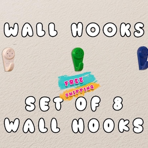 May include: Image of a set of eight wall hooks in beige, green, and blue. The text "WALL HOOKS" and "SET OF 8 WALL HOOKS" are displayed in a bubble font. A turquoise and yellow banner reads "FREE SHIPPING".