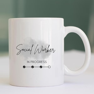 May include: White ceramic mug with a black and grey watercolour design. The mug has the text "Social Worker" and "IN PROGRESS" with a progress bar showing three check marks and one empty circle.