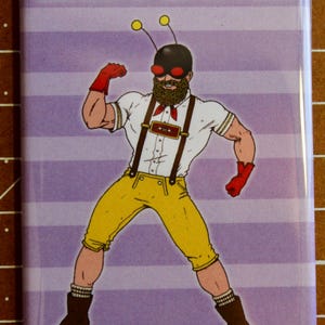 May include: A cartoon illustration of a man with a beard and a bee costume. He is wearing a white shirt, yellow pants, suspenders, and a black mask with red goggles. The text "BEARDO' BEES MAN™" is at the top of the image.