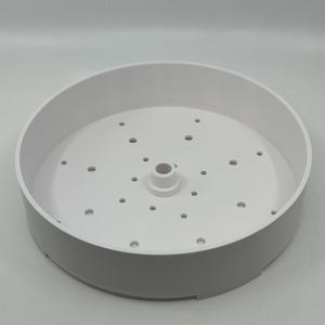 May include: White plastic steamer basket with a central hole and multiple small holes around the edge.
