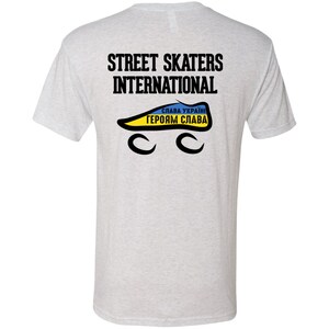 Puede incluir: Una camiseta gris jaspeada con el texto "STREET SKATERS INTERNATIONAL" impreso en la espalda. Debajo del texto hay una patineta negra y amarilla con el texto "СЛАВА УКРАЇНІ ГЕРОЯМ СЛАВА" impreso en ella.