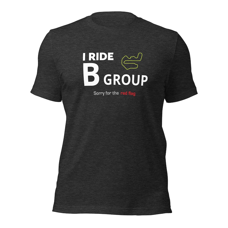 May include: A dark grey t-shirt with white text that reads "I ride B group" and a yellow track outline. The text "Sorry for the red flag" is also printed in white.