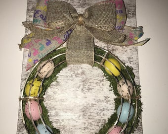 Hanging Easter egg wreath on faux wood background